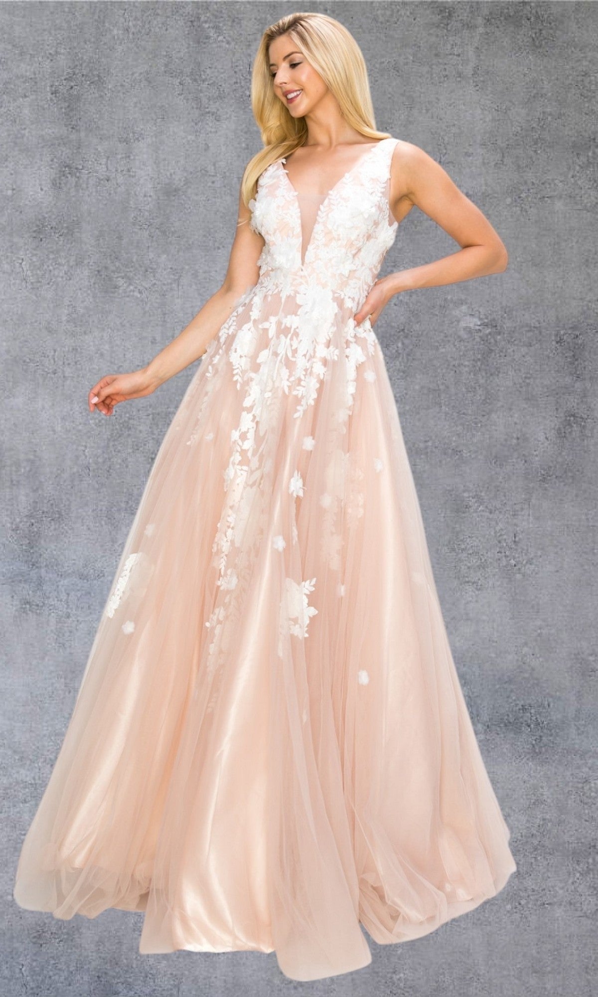 A woman in the Cinderella Couture 8040J Long Formal Dress, featuring a sleeveless blush tulle design with a deep V-neck and delicate 3D floral lace appliques, stands against a gray textured background for a dreamy look.